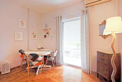 a dining room with a table and a lamp at Freshly Refurbished flat, in Central Koukaki in Athens