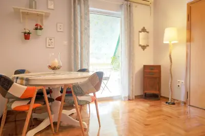a dining room with a table and chairs and a window at Freshly Refurbished flat, in Central Koukaki in Athens