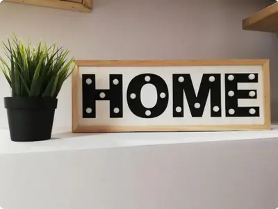 a black and white home sign on a table with a potted plant at Heart of Athens Studio 25sqm in Athens