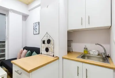 a kitchen with white cabinets and a sink at Heart of Athens Studio 25sqm in Athens