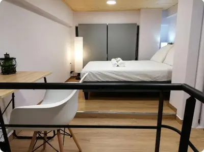 a bedroom with a bed and a desk and a chair at Heart of Athens Studio 25sqm in Athens