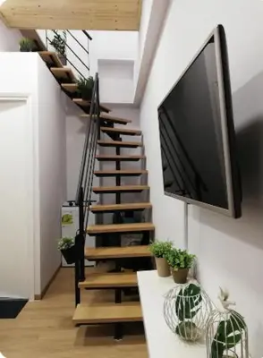 a living room with a tv and a staircase with plants at Heart of Athens Studio 25sqm in Athens
