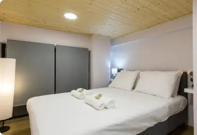 a bedroom with a white bed with towels on it at Heart of Athens Studio 25sqm in Athens