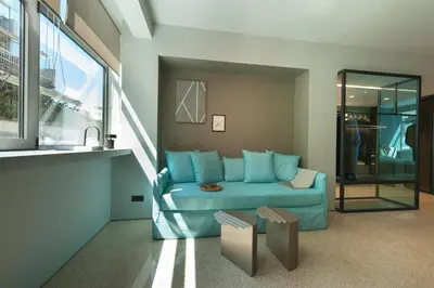 a living room with a blue couch and a window at Arcade Project Hi-end Apartments in Athens