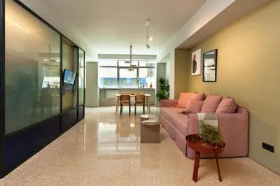 a living room with a pink couch and a table at Arcade Project Hi-end Apartments in Athens