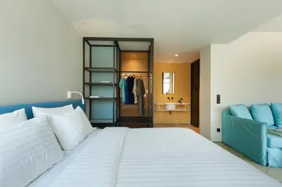 a bedroom with a large white bed and a bathroom at Arcade Project Hi-end Apartments in Athens