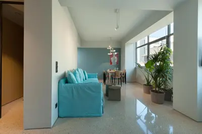 a living room with a blue couch and a table at Arcade Project Hi-end Apartments in Athens