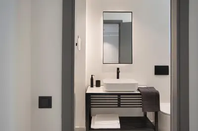 a white bathroom with a sink and a mirror at Glyfada South42 in Athens