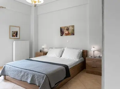 a bedroom with a large bed with white walls at Yellow house in Palaiá Fókaia
