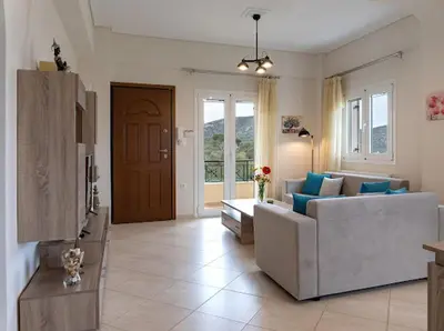 a living room with a couch and a table at Yellow house in Palaiá Fókaia
