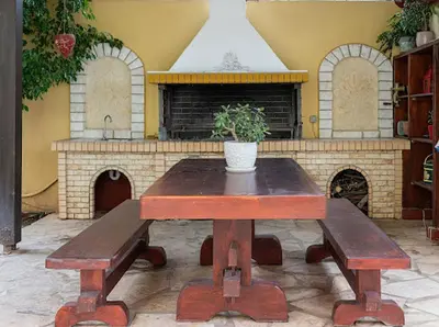 a table with a potted plant sitting on top at Yellow house in Palaiá Fókaia