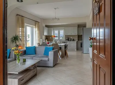 a living room and kitchen with a couch and a table at Yellow house in Palaiá Fókaia