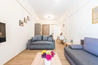 a living room with a couch and a table with flowers at Exeptional Apartment in Athens