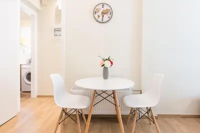 a white dining room with a white table and chairs at Exeptional Apartment in Athens
