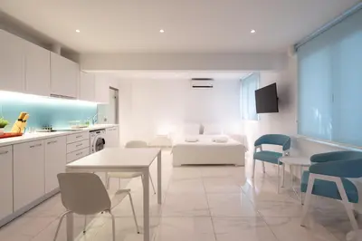 a white kitchen with a bed and a table and chairs at Cute and Convenient Studio in Athens Center in Athens