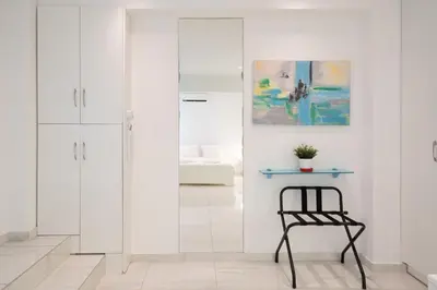 a white bathroom with a blue table and a chair at Cute and Convenient Studio in Athens Center in Athens