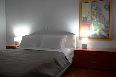 a bedroom with a bed with a painting on the wall at Modern & Classy Central Apartment in Athens