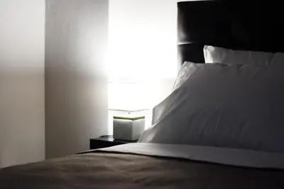 a bedroom with a bed with a white pillow and a lamp at Modern & Classy Central Apartment in Athens