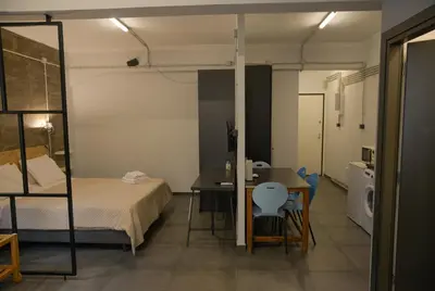 a small room with a bed and a table and a kitchen at Virginia's Boutique Apartments in Athens