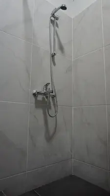 a shower stall with a shower head on a wall at Virginia's Boutique Apartments in Athens