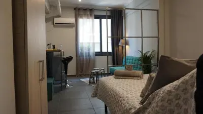 a bedroom with a bed and a living room at Virginia's Boutique Apartments in Athens