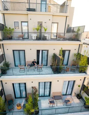 an apartment building with a man sitting on the balcony at PAME Paradiso in Athens