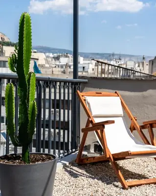 a chair and a cactus on a balcony at PAME Paradiso in Athens