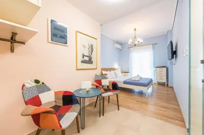 a room with a bed and a table and chairs at Thissio Cocoon in Athens