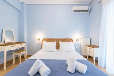 a blue and white bedroom with a bed with two pillows at Thissio Cocoon in Athens