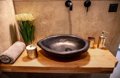 a stone sink on a wooden counter with a vase of flowers at Triple A - Graffiti Homage in Psirri Square - FREE Parking! in Athens