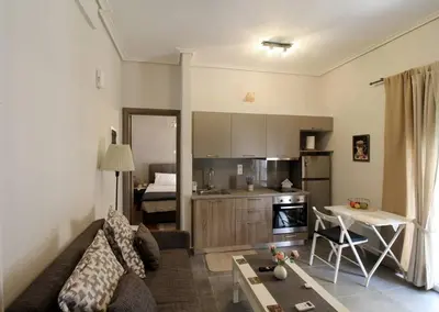 a living room with a couch and a kitchen at Luxury flat in Hilton, central Athens, 3' metro, VFM! in Athens