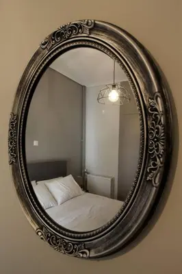a mirror hanging on a wall with a bed at Luxury flat in Hilton, central Athens, 3' metro, VFM! in Athens