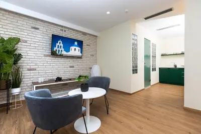 a room with a table and chairs and a brick wall at SUITES@SYNGROU-FIX in Athens