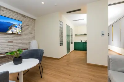 a living room with a table and a tv on a brick wall at SUITES@SYNGROU-FIX in Athens