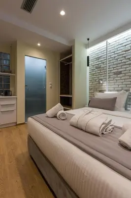 a bedroom with a large bed with a large window at SUITES@SYNGROU-FIX in Athens