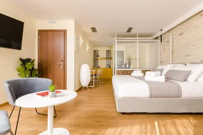 a bedroom with a large bed and a table at SUITES@SYNGROU-FIX in Athens