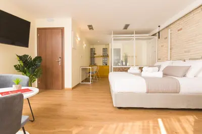 a bedroom with a large white bed and a table at SUITES@SYNGROU-FIX in Athens