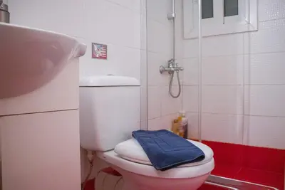 a bathroom with a toilet with a blue towel on it at City Stay close to the National Museum in Athens