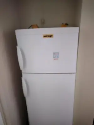 a white refrigerator in a corner of a room at Perikleous Apartment in Athens
