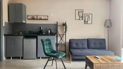 a living room with a blue couch and a kitchen at Boutique Studios & Apartments - by Avelink in Spáta