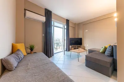 a living room with a couch and a television at Boutique Studios & Apartments - by Avelink in Spáta