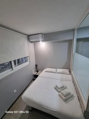 a small bedroom with a bed with towels on it at athens.apartotel.box in Athens