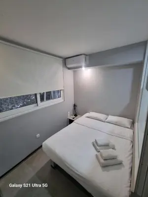 a bedroom with a bed with two towels on it at athens.apartotel.box in Athens