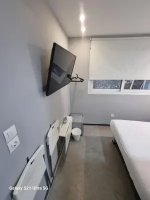 a hospital room with a bed and a tv on the wall at athens.apartotel.box in Athens