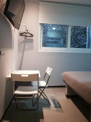 a bedroom with a desk and a chair and a bed at athens.apartotel.box in Athens