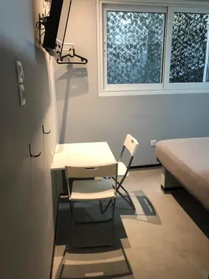 a desk and a chair in a room with a window at athens.apartotel.box in Athens