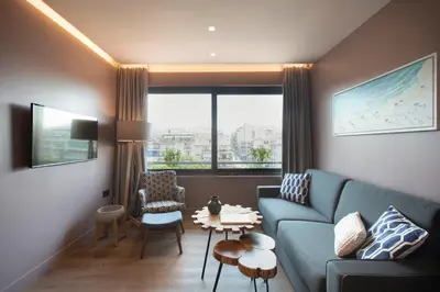 a living room with a blue couch and a large window at City Lights Athens by YHA in Athens