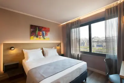 a hotel room with a bed and a large window at City Lights Athens by YHA in Athens