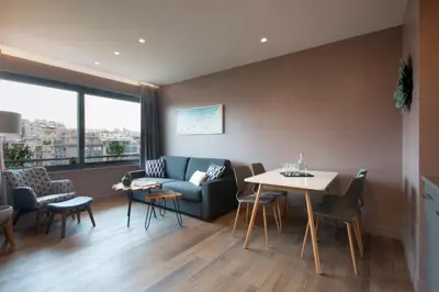 a living room with a couch and a table and chairs at City Lights Athens by YHA in Athens