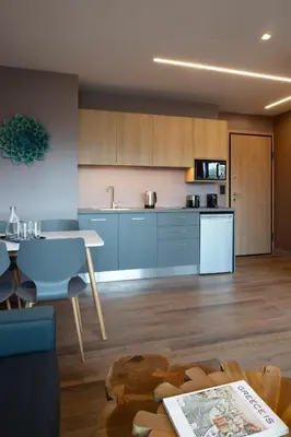 a kitchen with blue cabinets and a table at City Lights Athens by YHA in Athens